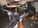 1979 Ford Bronco - Front axle assembly being worked on, with a plumb bob used for alignment.